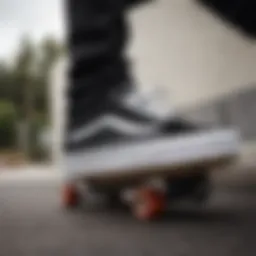 Low top black and white Vans on a skateboard